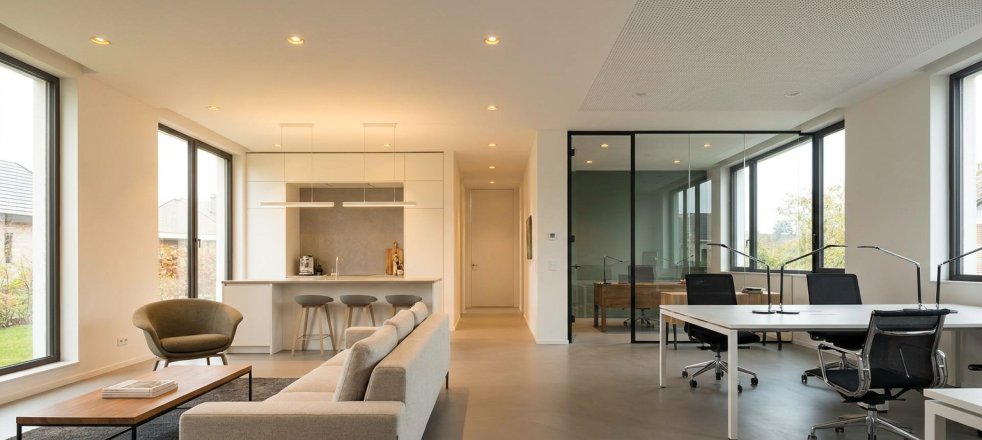 Modern office and lounge interior with recessed ceiling lights and large windows